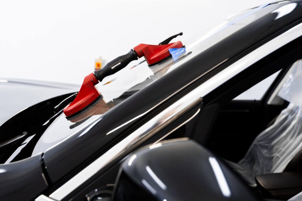 dreamstime_m_393689182 Windshield replacement using lifting tools that grip glass securely. Windshield technicians rely on vacuum lifters for glass removal.